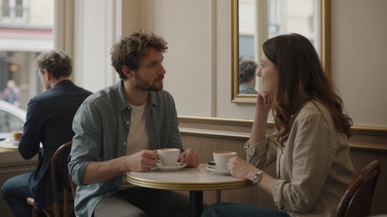 Two people sit quietly in a Paris café, having a respectful, private conversation over coffee.